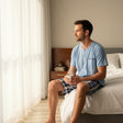 Button henley pyjama set worn sitting on a bed with a coffee mug