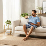 Button henley pyjama set worn on a sofa with a tablet and coffee
