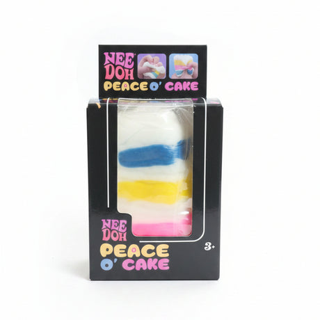 Rainbow layer cake slice sensory toy in black retail box, white squishy with blue, yellow and pink stripes