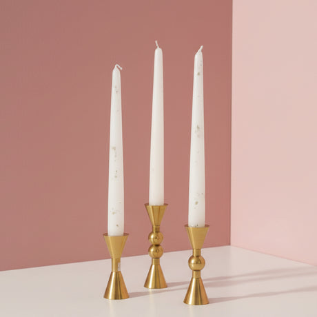 An hourglass, a single bead and a double bead holder in gold with white tapers