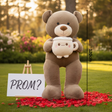 Mocha teddy bear standing in a garden with a smiling latte mug plush