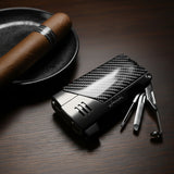 Carbon fiber lighter with tools on a wooden surface next to a cigar