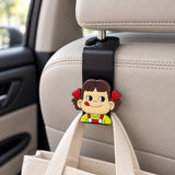 Black car headrest hook with a cartoon girl topper in green overalls holding a canvas tote bag