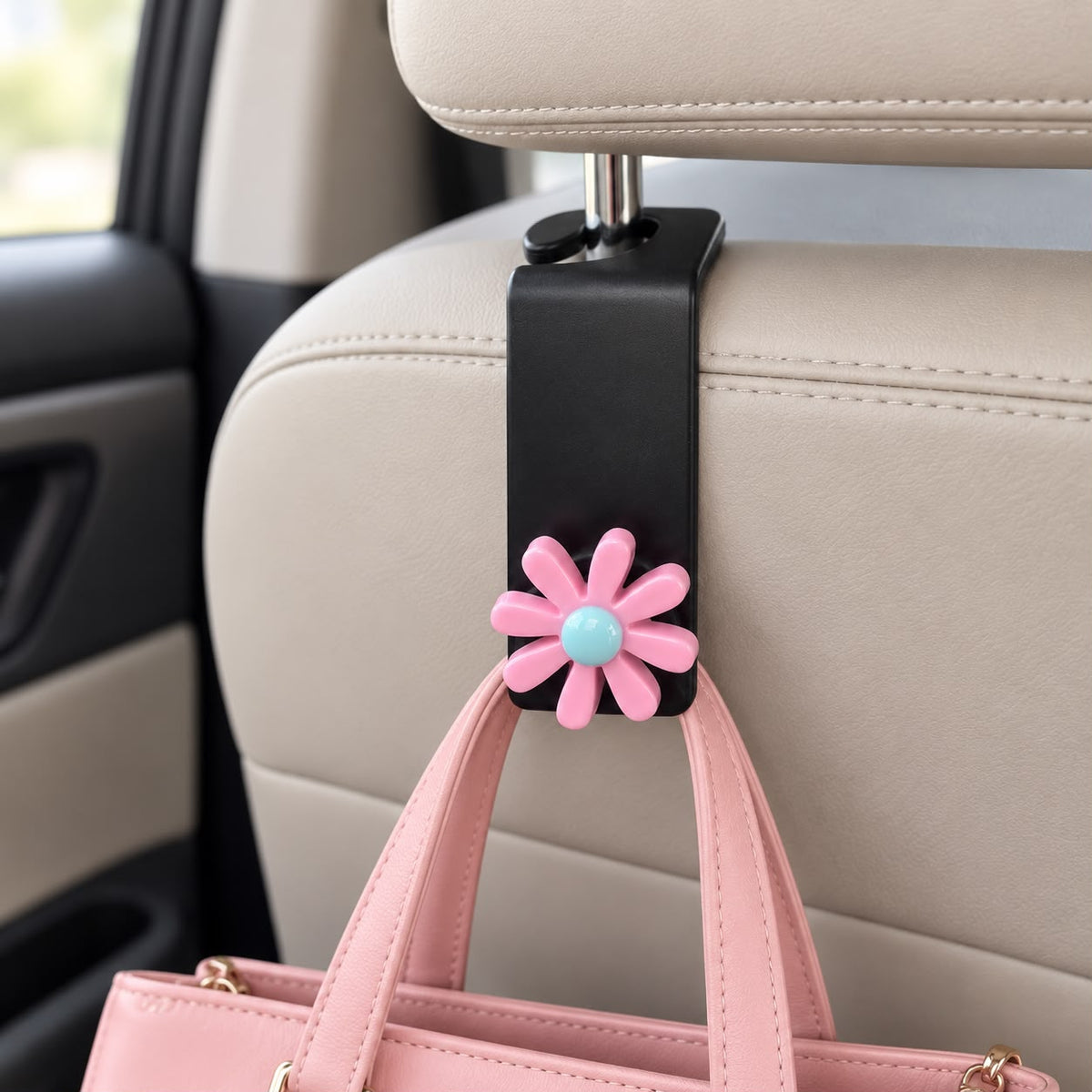 Car headrest hook with a pink daisy flower topper and blue centre holding a pink handbag