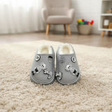Grey mule slippers with cartoon figure and script charms on a rug