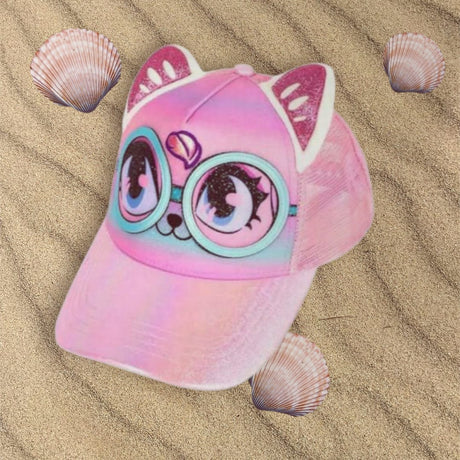 Pink cat kids cap with sparkly 3D ears, cartoon eyes and a pastel brim resting on sand