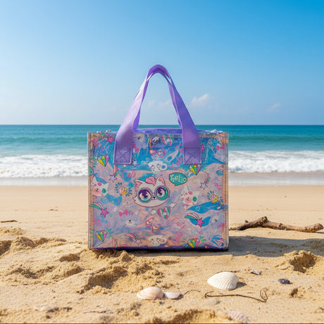 Purple trimmed clear cat print tote resting on sand with seashells and blue sea behind