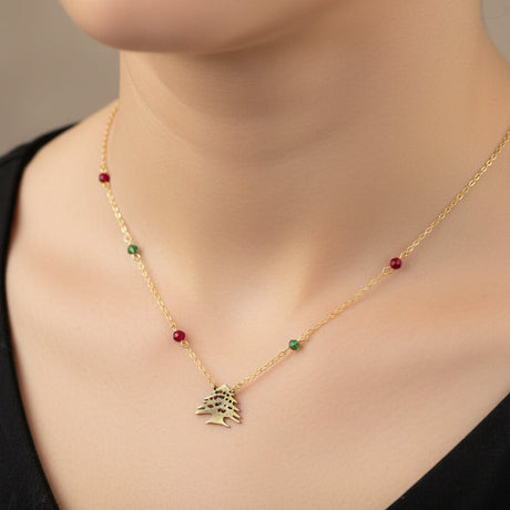 Gold necklace with a cedar tree pendant and beads worn by a woman
