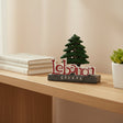 Standing souvenir with a dark green cedar tree behind the word Lebanon in raised red