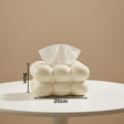Glossy cream bubble tissue box on a round white table, a tissue pulled up, 20cm by 9cm