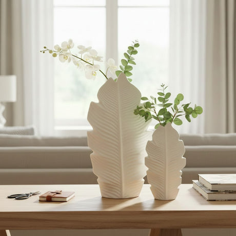 Tall and short leaf vases together on an oak console with a white orchid and eucalyptus