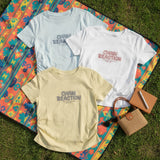 Three Chain Reaction slogan tees laid on a patterned picnic mat