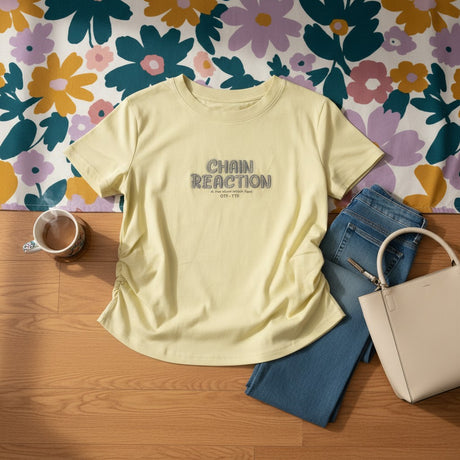 Pastel yellow Chain Reaction tee styled with jeans, a bag and coffee