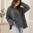 Charcoal grey oversized knit sweater with a centre front seam and ribbed hem, worn with light jeans