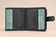 Charcoal nubuck interior lined with teal cards, the snap tab resting on the right edge