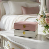 Dusty rose and cream textured faux leather jewelry boxes stacked with gold clasps
