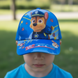 Royal blue kids cap with a police pup and a Top Pups brim, worn outdoors
