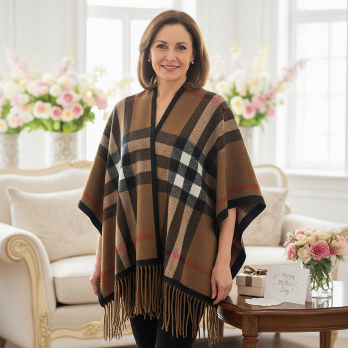 Woman wearing a checkered puncho in a bright room with flowers and furniture