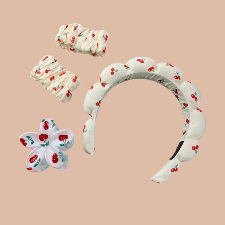 White cherry print spa headband with matching wrist bands and a flower claw clip