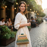 Woman carrying a colorful chevron clutch by its gold chain strap