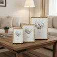 Three gold photo frames arranged on a wooden coffee table