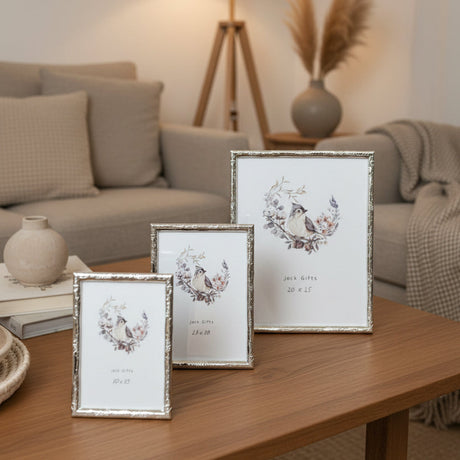 Three silver photo frames in different sizes on a living room coffee table