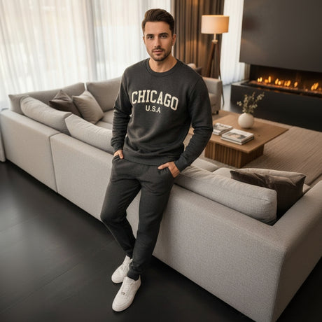 Man wearing a dark grey 'Chicago USA' sweatshirt and sweatpants in a living room