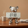 Silver bear-shaped clock with digital display on a wooden surface.
