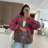 Taupe and fuchsia striped cardigan, one hand resting on the pocket, styled at home