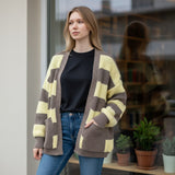 Pastel yellow stripe cardigan with deep front pockets, seen from a slight angle