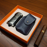 Cigar lighter and leather case in an open orange box on a wooden surface