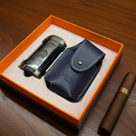 Cigar lighter and leather case in an open orange box on a wooden surface