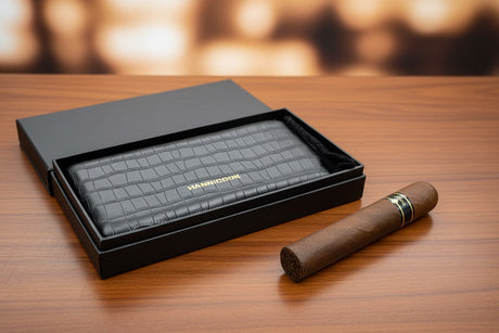 Branded black leather cigar case with a cigar on a wooden surface