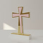 Flared acrylic cross in pale pink with a gold mirrored cross running down its shaft