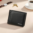 Classic black leather wallet on a beige surface with a watch, keys and a cup