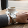 Classic silver watch with a white dial orn on a person's wrist