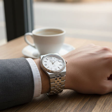 Classic silver watch with a white dial orn on a person's wrist