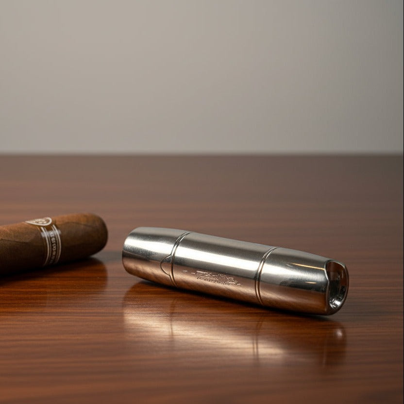 Silver metal cigar lighter on a wooden surface with a plain background