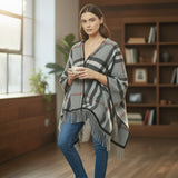 Woman wearing a classic plaid puncho in a cozy room with bookshelves and a window