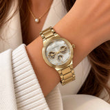 Gold multi dial watch with pearl face and three subdials worn on the wrist