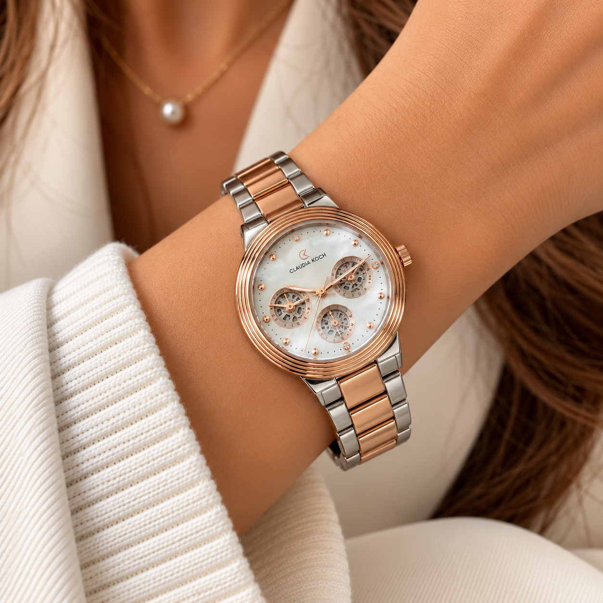 Rose gold and silver two tone multi dial watch worn with a pearl necklace