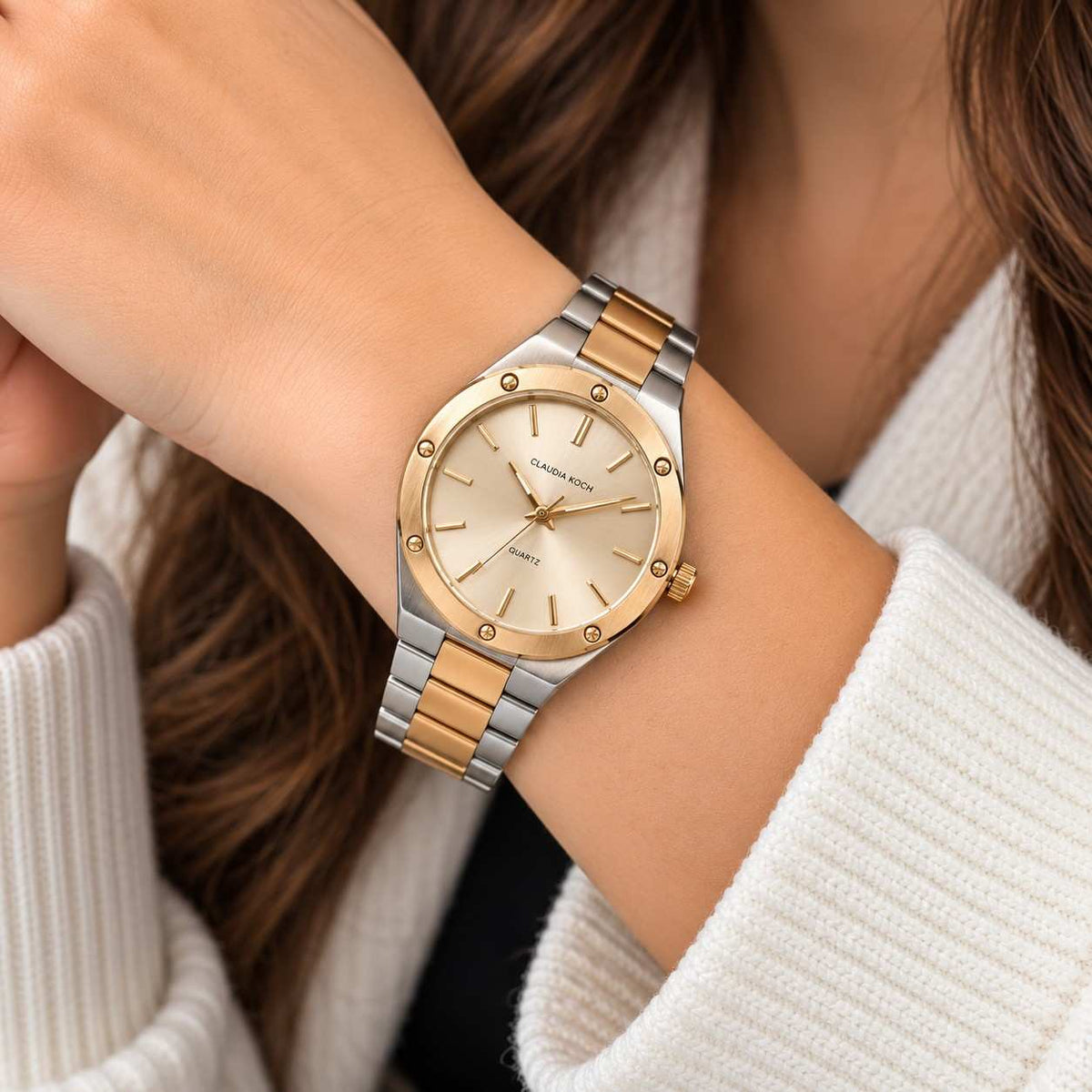 Two tone steel and gold watch with champagne dial worn with a cream sweater