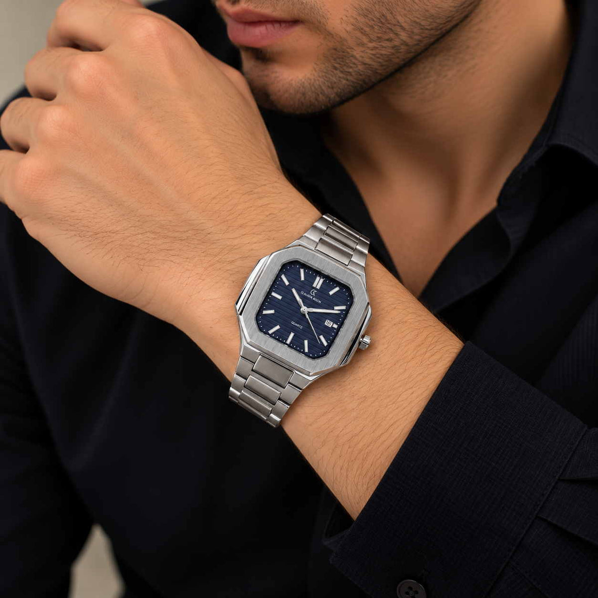 Silver octagon watch with ribbed navy dial worn on a man's wrist