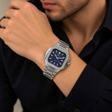 Silver octagon watch with ribbed navy dial worn on a man's wrist