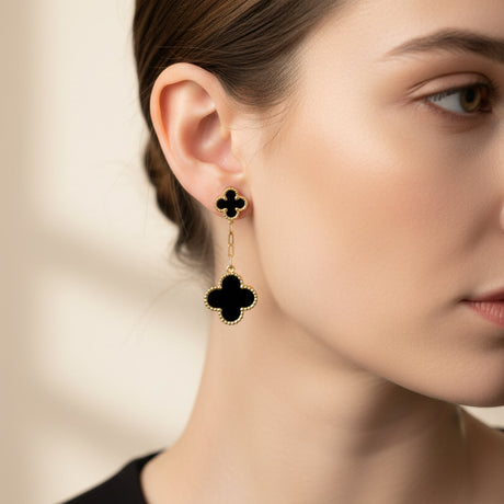 Clover-shaped earrings worn by a woman on a blurred background