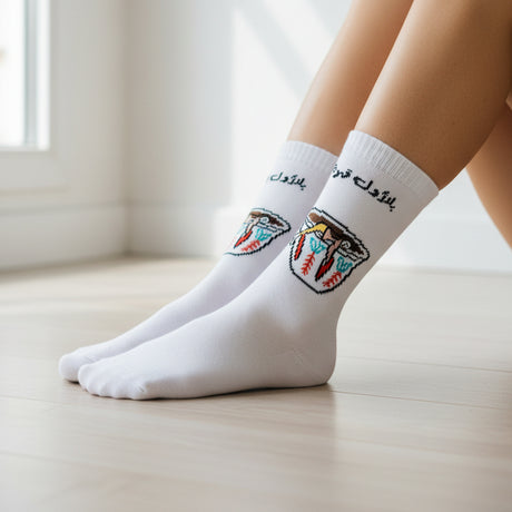 Person wearing white socks with colorful design on a wooden surface