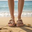 Pair of beige sandals on sand