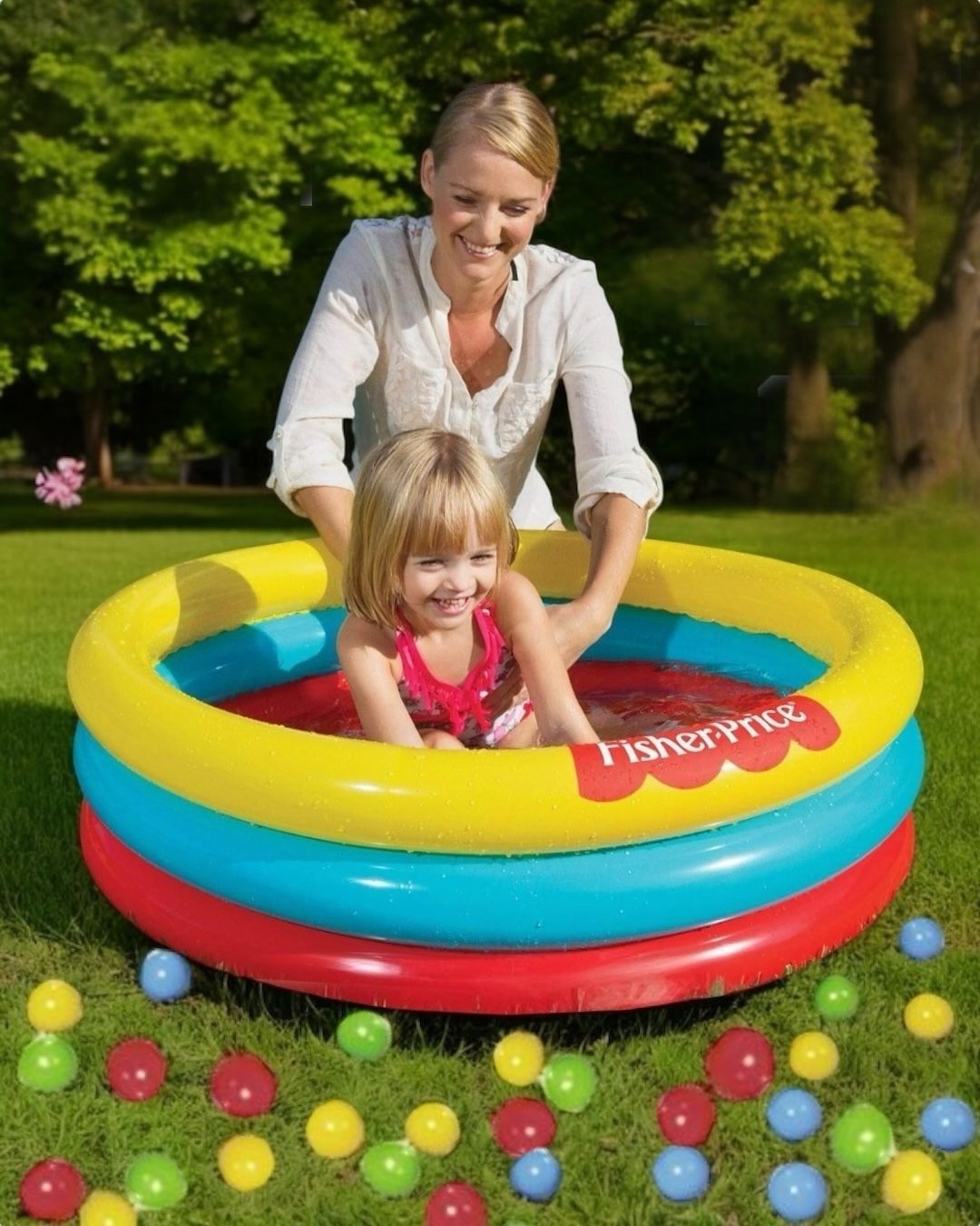 Yellow, blue and red three ring baby pool on grass with a child inside and play balls scattered around