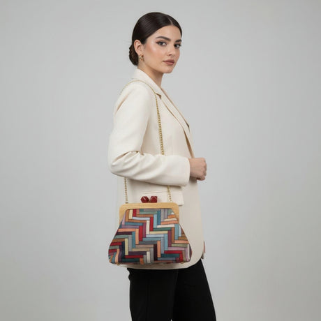 Woman holding a colorful handbag against a plain background