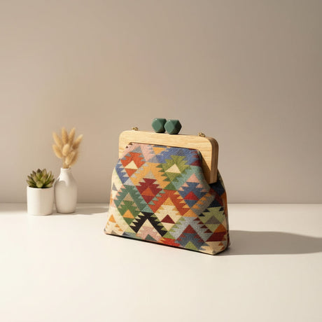 Green, red and yellow triangle weave handbag on a cream tabletop